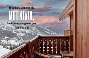 Mountain view from wooden balcony with snow, sunset sky, and inspirational quote overlay