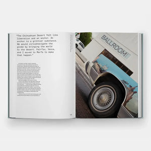 Open book displaying a quote about the Chihuahuan Desert on the left and a photograph on the right featuring a classic car with a painted mural and the sign 'Ballroom Marfa'.