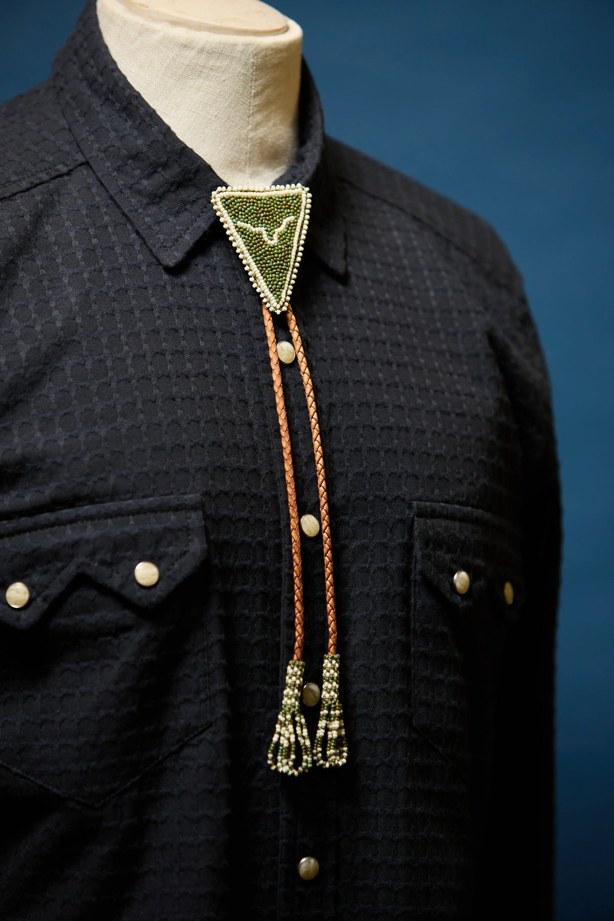 Richter194 front, close front view of textured black western pearl snap shirt with beaded bolo tie