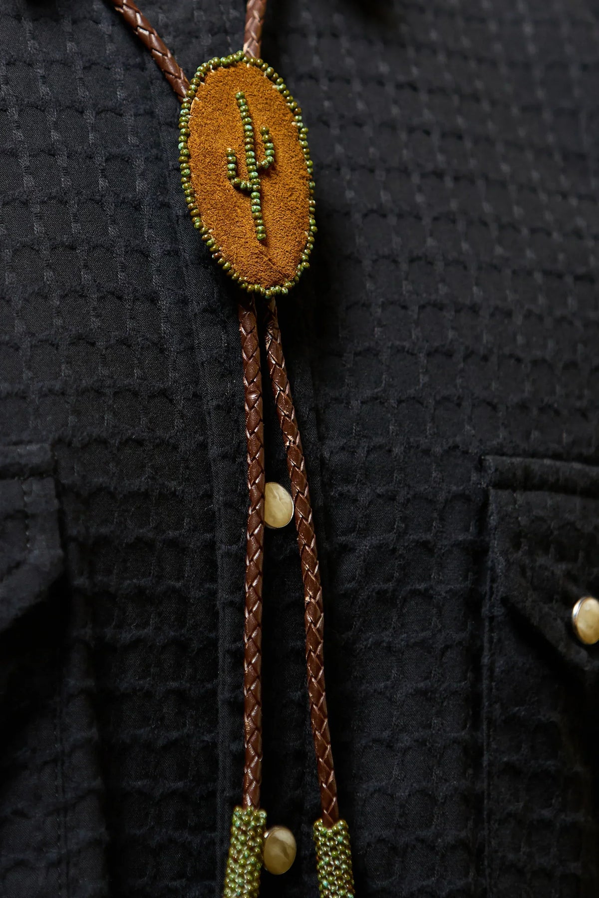 Richter199 front view close-up, brown leather bolo tie with cactus beading on black western shirt