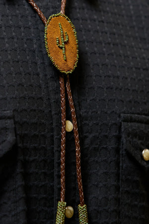 Richter199 front view close-up, brown leather bolo tie with cactus beading on black western shirt