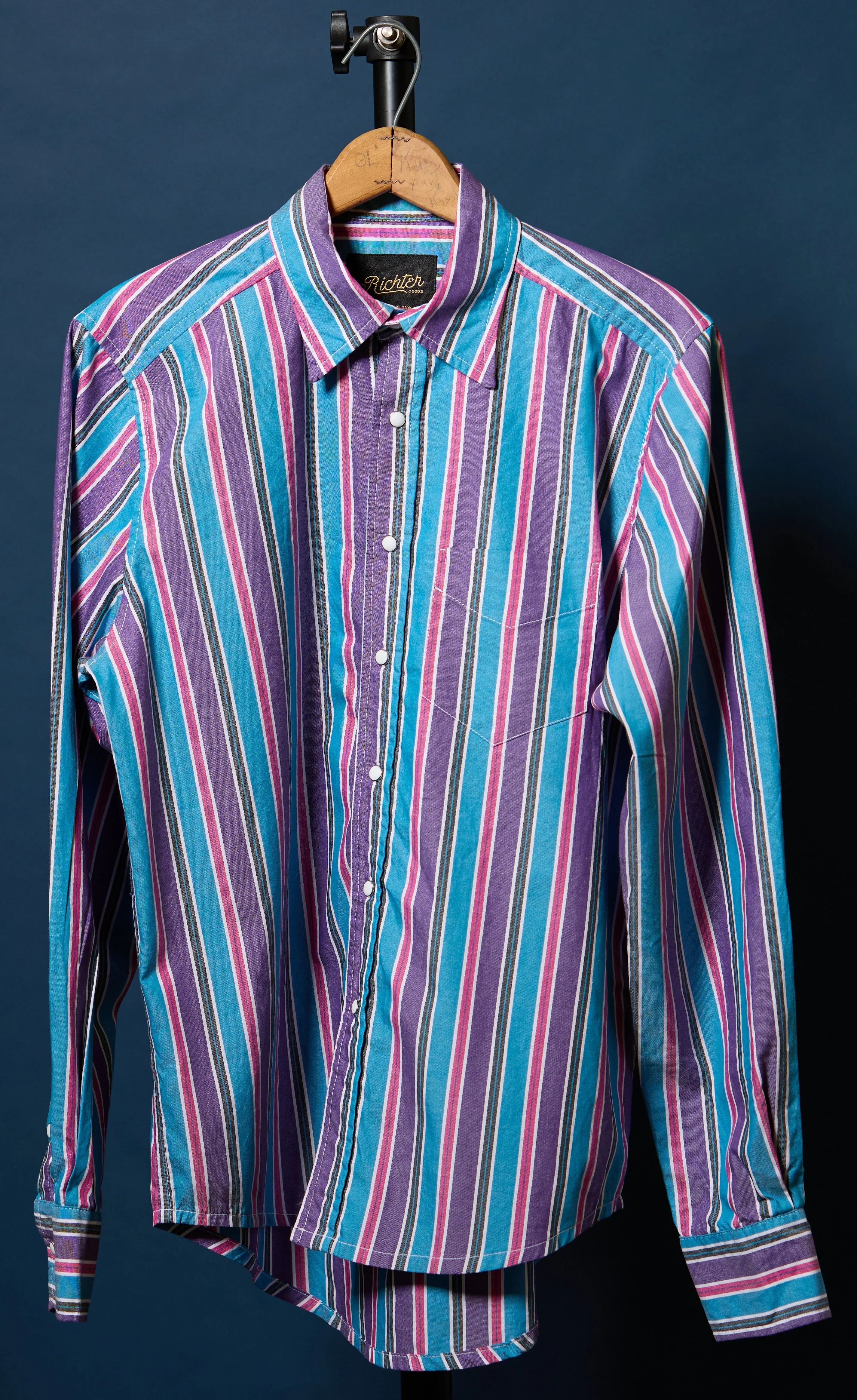 Striped shirt on a hanger against a dark background