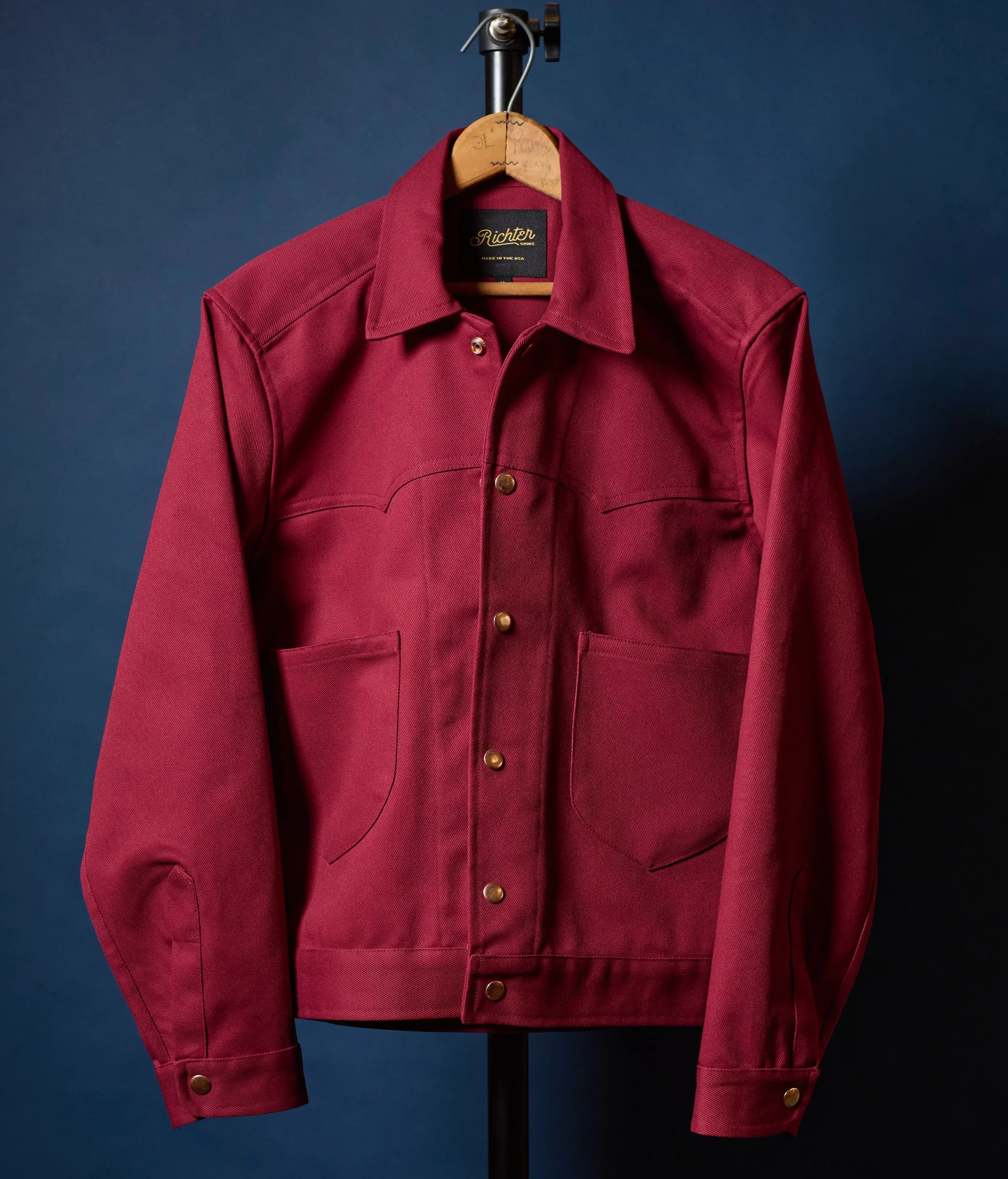 Red jacket on a hanger against a blue background
