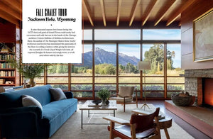 Modern chalet living room with large windows, blue sofa, fireplace, and mountain view in Jackson Hole, Wyoming