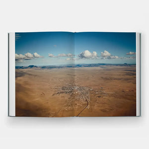 cc9024cdcbb168048da8353f9663f6a29a8f17c084009aafee353b5cb2986ee9 front, aerial view of desert town in an open book