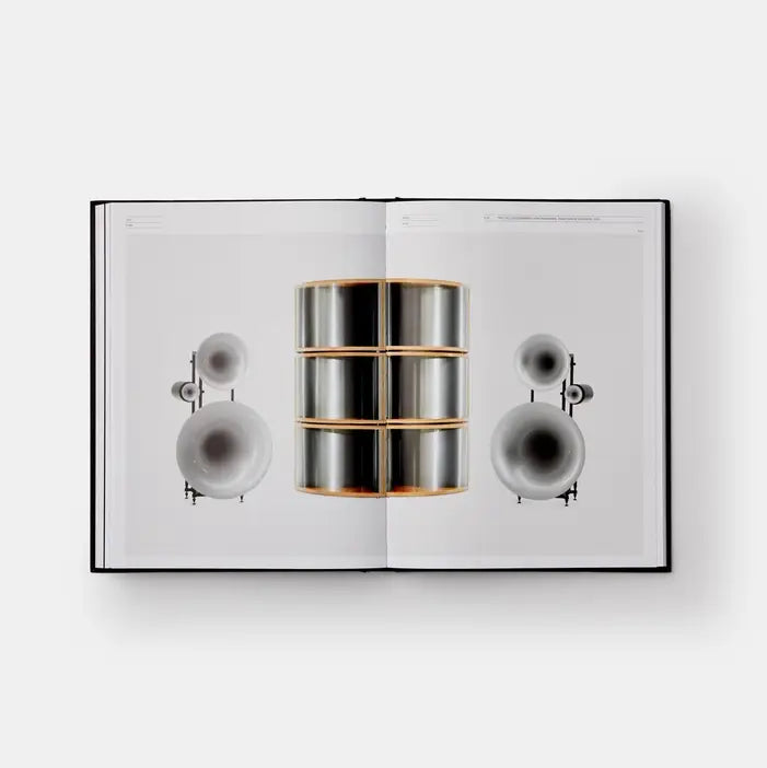 Open book displaying a metallic cylindrical object with a white background