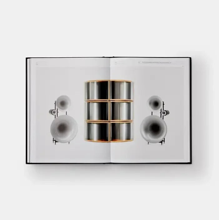 Open book displaying a metallic cylindrical object with a white background