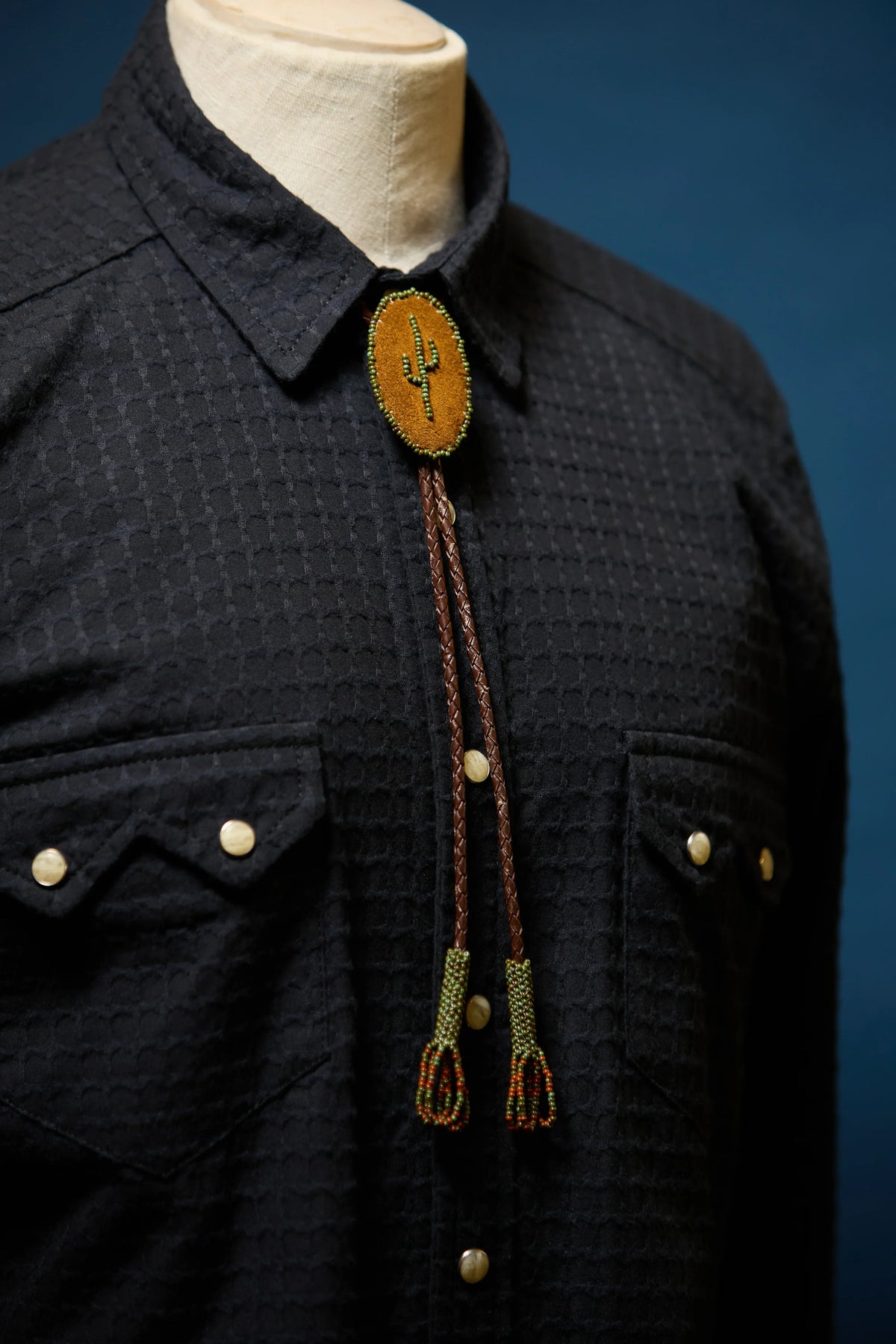Richter198 front, close view of black western pearl snap shirt with cactus bolo tie