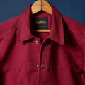 Rhubarb Red jacket on a hanger with 'Richter' label against a blue background