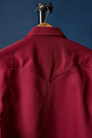 Red jacket back side on a hanger against a blue background