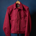Red jacket on a hanger against a blue background
